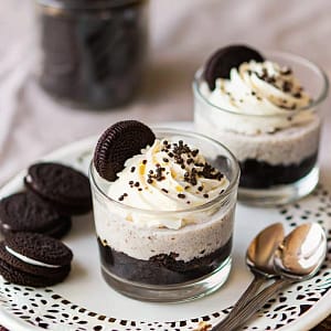 Plate of delicious no-bake Oreo cheesecake bites with chocolate drizzle and Oreo crumbs.